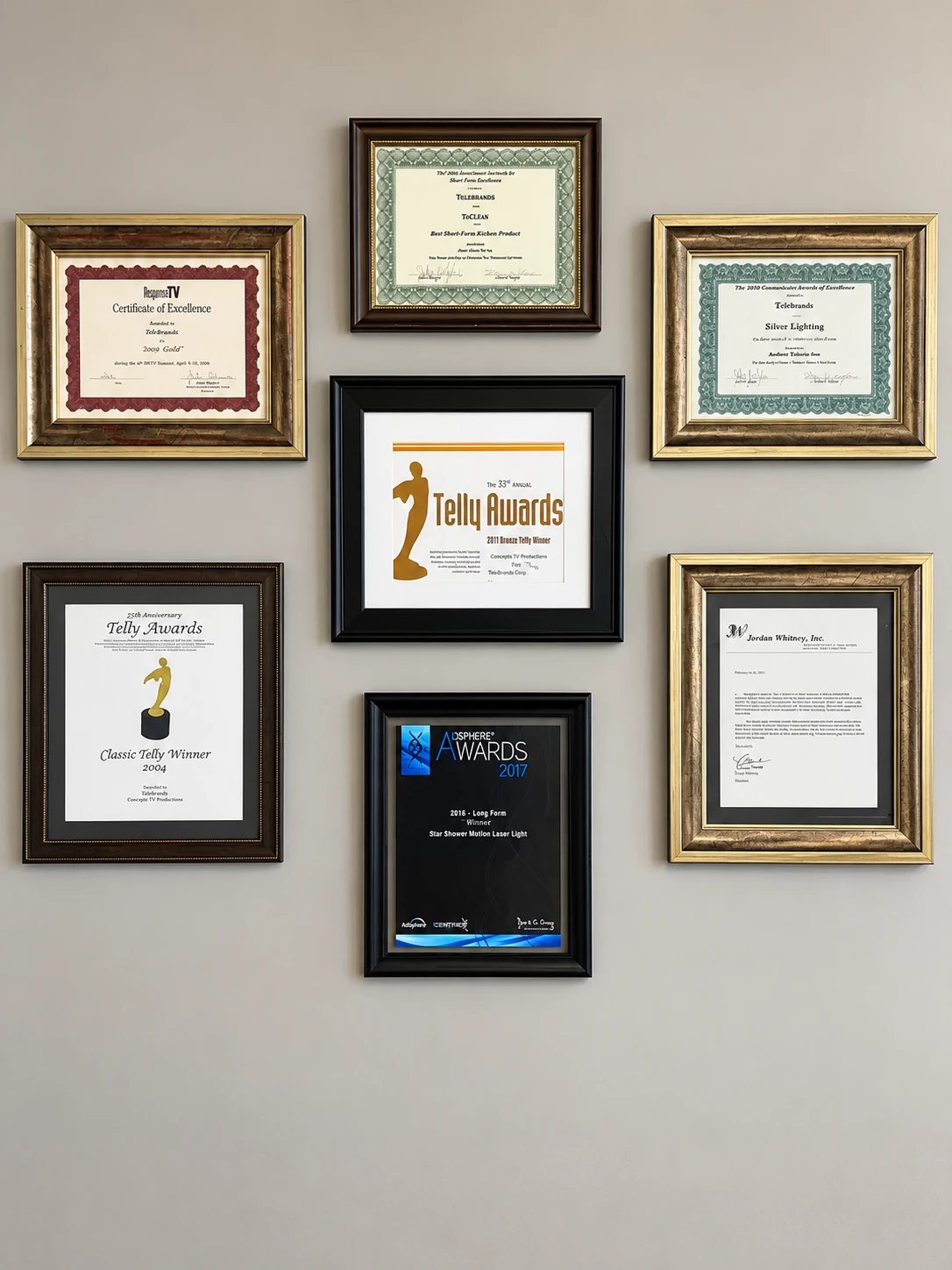 Framed award collection including Telly certificates and a 2017 AdSphere certificate naming Star Shower Motion Laser Light