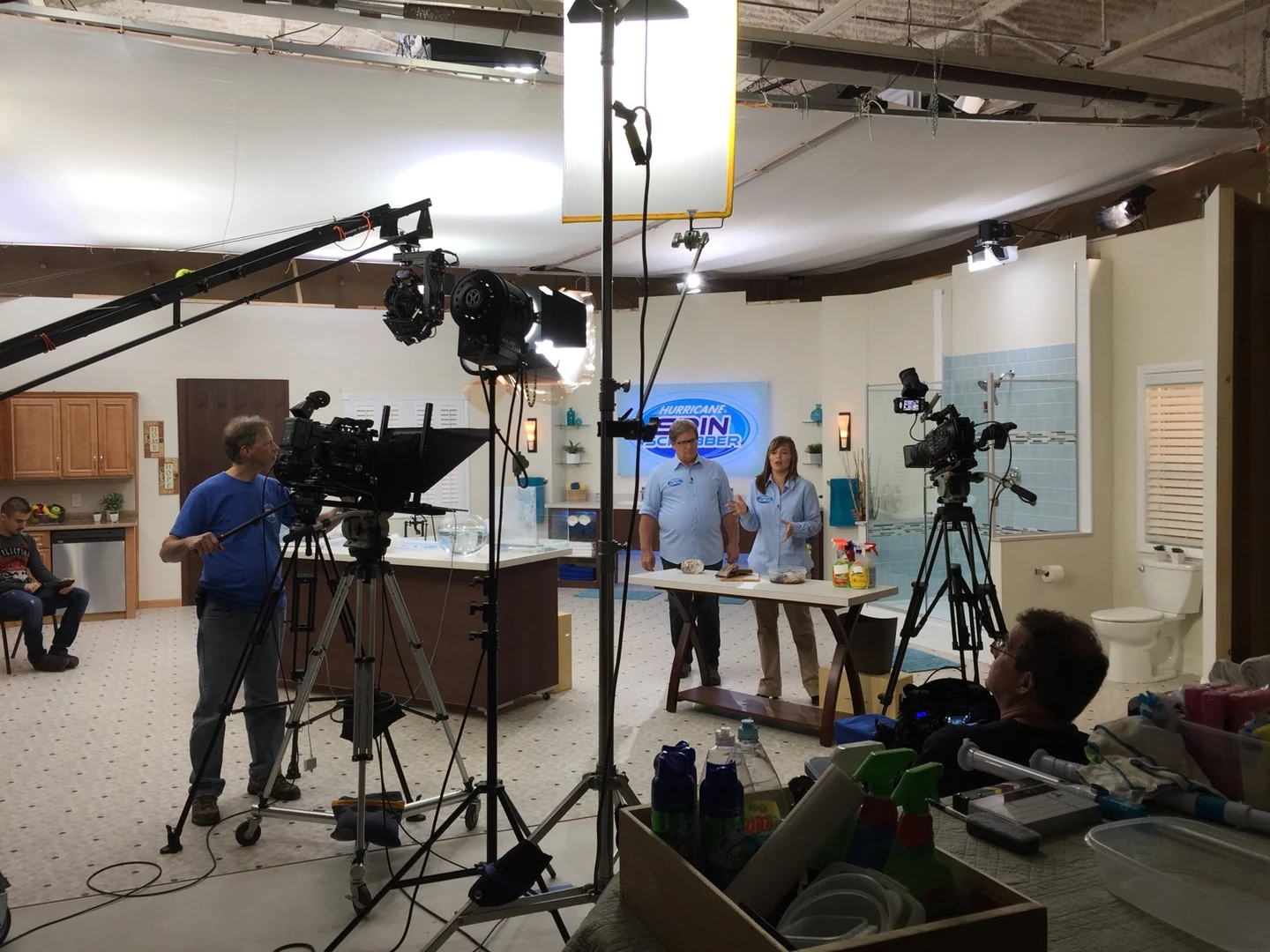 A camera crane and crew filming a demonstration on a kitchen studio set