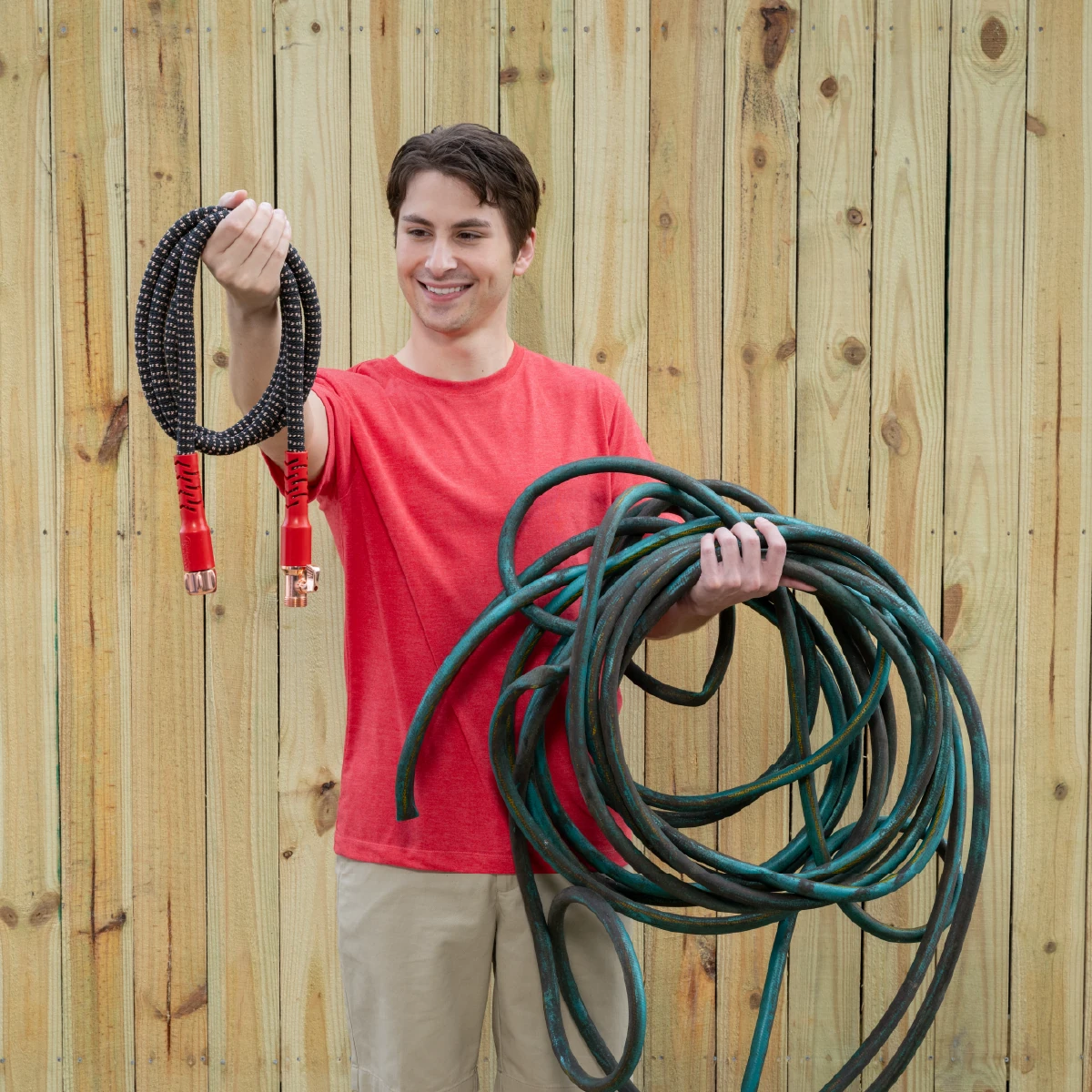 A demonstrator holding a compact Copper Head hose alongside a conventional garden hose